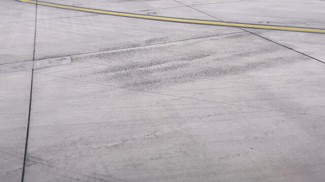 View of the airpot tarmac moving over the runway towards docking from passenger view.