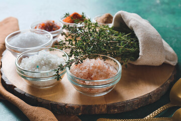 Composition with different salt and thyme on color background, closeup
