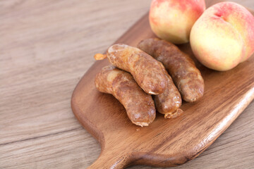 Pork enema and fresh peaches on cutting board