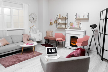 Stylish interior of modern living room with fireplace and laptop