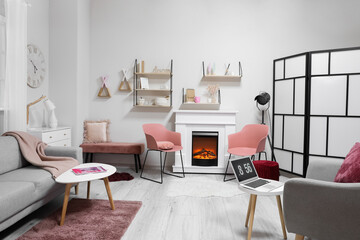 Stylish interior of modern living room with fireplace and laptop