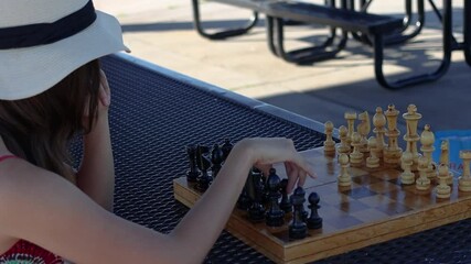 The first response. A woman makes a good move in a game of recreational chess.