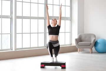 Sporty young woman training at home
