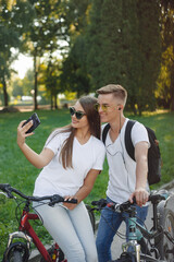 Fototapeta premium Couple riding bikes in summer forest