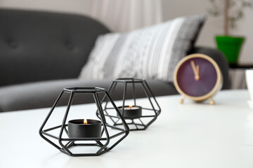 Burning candles on table in room