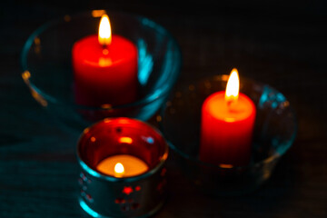 Red decorative candles, blurry image. Home decor items. The bright light of burning candles in disfocus