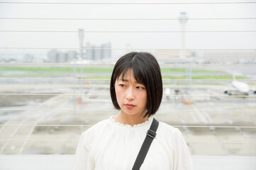 空港の展望デッキから景色を眺める女性