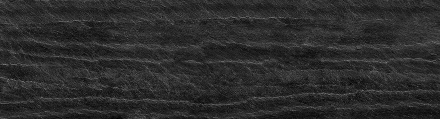 Black grunge background. Dark gray stone background with copy space. Black grunge banner with rock texture. Rock background with cracked surface.