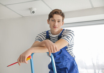 Worker installing alarm system indoors