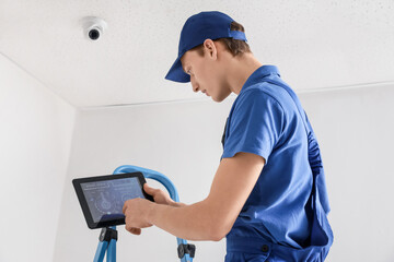 Worker installing alarm system indoors