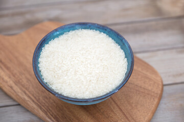 A bowl of white rice on a cutting board