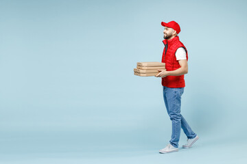 Full size body length delivery employee man in red cap white T-shirt vest uniform work dealer courier hold pizza in cardboard flatbox isolated on pastel blue color background studio. Service concept.