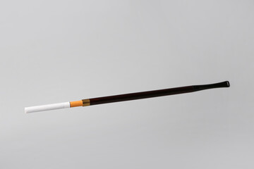 Cigarette with stick on light background