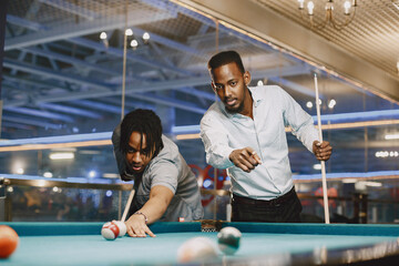 Men playing billiards in a club