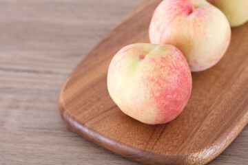Three peaches on cutting board