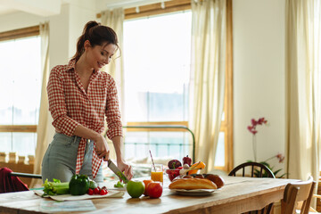 Young woman preparing a vegetarian lunch with fresh vegetables.