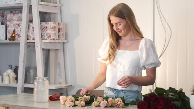 Woman ctting and sorting roses in flower shop
