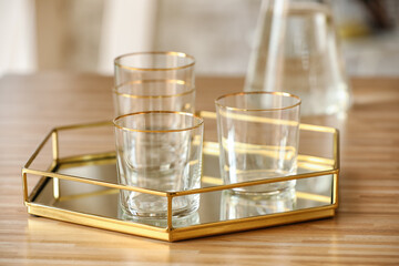 Tray with beautiful empty glasses on wooden table