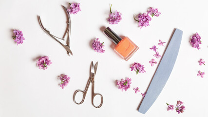 Flat lay composition with personal care products with branches of lilac on white table.background. Nails care. Manicure, pedicure beauty salon concept.