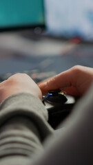 Close up on hands of video game r playing using wireless joystick in cyberspace sitting on gaming chair. Cyber man holding controller performing space shooter video games at online esports