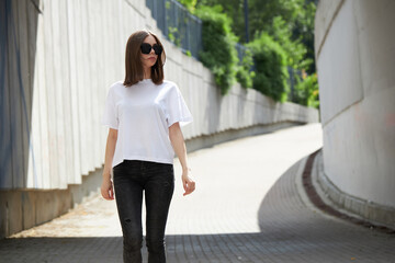 Girl or woman wearing white blank t-shirt with space for your logo, mock up or design in casual urban style