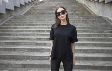 Woman or girl wearing black blank cotton t-shirt with space for your logo, mock up or design in...