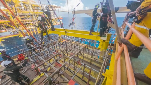 4K time lapse of offshore workers performing heavy lifting works for extension deck at gas platform in the middle of the sea.