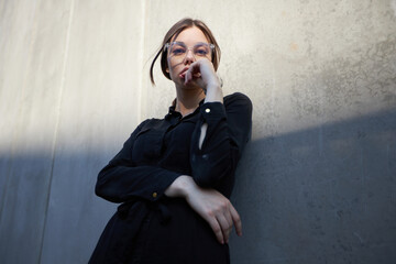 Fashion headshot of a sexy brunette woman with a make up wearing black clothes outside in urban...