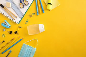 School supplies on yellow with covid-19 protection isolated