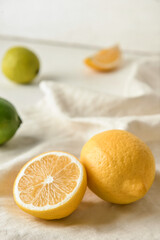 Fototapeta na wymiar Healthy lemons and limes on light fabric background