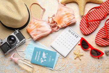 Calendar with beach accessories, medical masks and immune passport on grunge background