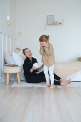 two sisters are sitting in the bedroom and talking and laughing