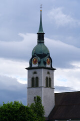 Clock tower of catholic church at Emmen-Rathausen on a cloudy and rainy summer day. Photo taken June 22nd, 2021, Emmen, Switzerland.
