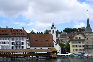 Obraz premium Medieval old town of Lucerne with famous Kappelbrücke (Chapel Bridge) on a cloudy summer day with river Reuss. Photo taken June 22nd, 2021, Luzern, Switzerland.