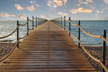 Wooden pier extending into the sea at sunrise