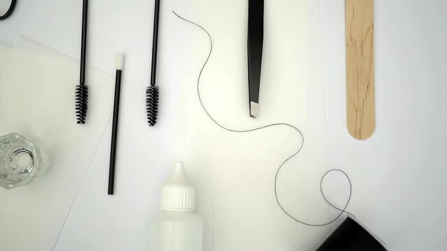 Beauty treatment tools, products and equipment arranged in flat lay style and shot from above. Waxing and tinting beauty salon tools filmed in slow motion with simple neutral colour palette