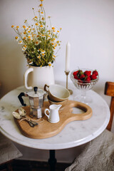 steel moka pot with two cups and two spoons on a wooden board. preparing for breakfast with fresh coffee. morning with coffee in Italian style