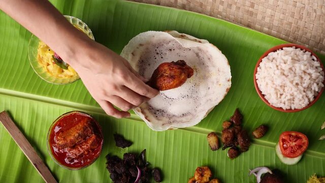 Hand serving chicken fry Appam Non-vegetarian sadhya Indian food Onam sadya sadhya Christmas Easter celebration Kerala India Sri Lanka 4K slow motion video hoppers beef fry fish curry rice banana leaf