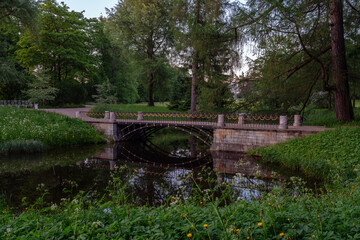 The bridge over the Upper Ponds to the kitchen ruins in Catherine Park in Tsarskoye Selo on a sunny summer evening. Pushkin, St. Petersburg. Russia.