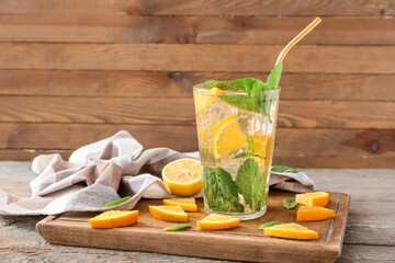 Glass of tasty ice tea with lemon on wooden background