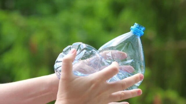 Crushing the plastic bottle with hands in 4k slow motion 60fps