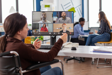 Handicapped paralyzed invalid employee during virtual meeting talking on videocall working from...