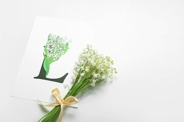 Beautiful lily-of-the-valley flowers and greeting card on white background