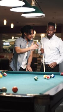 Two male friends starting snooker game in a club