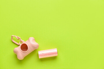 Dispenser with pet waste bags on color background