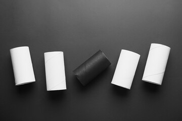 Cardboard tubes on dark background. Concept of racism