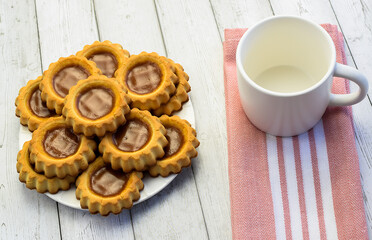 White empty cup, kitchen cotton napkin on light wooden background, close-up. Concept of breakfast, afternoon tea. Top and side view.