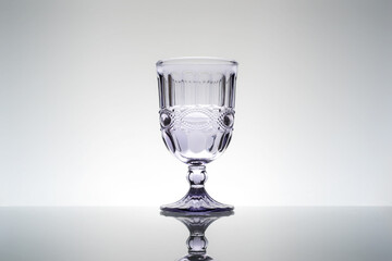 A finely decorated crystal cup on a neutral background, still-life composition