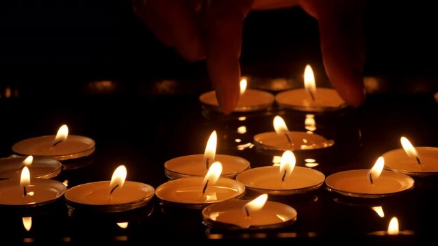 Close up burning candles floating on water surface in dark. Scented aroma candles float in dark water while relaxing spa therapy