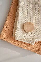Handmade natural olive soap lies on a natural muslin towel. Composition in beige. View from above.